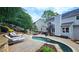 Backyard features a pool with stone accents, spiral staircase access to a balcony, and outdoor kitchen and entertaining areas at 1657 Millhouse Lndg, Marietta, GA 30066
