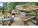 Backyard showcases outdoor kitchen with bar seating, fireplace, grill and umbrella-shaded dining for outdoor enjoyment at 1657 Millhouse Lndg, Marietta, GA 30066