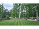 Spacious backyard with a lush green lawn and mature trees providing shade and privacy at 1657 Millhouse Lndg, Marietta, GA 30066