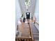 Bright two-story foyer with hardwood floors, staircase with carpeted treads, chandelier and arched doorway at 1657 Millhouse Lndg, Marietta, GA 30066