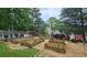 Landscaped backyard with raised garden beds, a gravel path, and a cozy seating area with chairs at 1657 Millhouse Lndg, Marietta, GA 30066