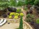 Landscaped backyard featuring a stone retaining wall, garden area with lush greenery, and stone steps at 1657 Millhouse Lndg, Marietta, GA 30066