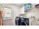 Efficient laundry room with front-load washer/dryer, countertop, and natural light at 1657 Millhouse Lndg, Marietta, GA 30066