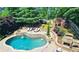 Beautiful pool area with lush landscaping, stone waterfall, and outdoor fireplace at 1657 Millhouse Lndg, Marietta, GA 30066