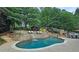 Landscaped backyard featuring a luxurious in-ground pool with stone waterfalls, sunbathing area and an outdoor dining space at 1657 Millhouse Lndg, Marietta, GA 30066