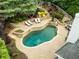 Aerial view of a stunning backyard pool with stone accents, patio, outdoor fireplace, and lush landscaping at 1657 Millhouse Lndg, Marietta, GA 30066