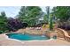 Beautiful pool with stone waterfalls, lush landscaping, and a sunbathing area, creating a tranquil outdoor oasis at 1657 Millhouse Lndg, Marietta, GA 30066