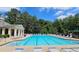 Community swimming pool with ample lounge chairs, surrounded by lush greenery and trees at 1657 Millhouse Lndg, Marietta, GA 30066