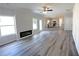 Open-concept living room with modern fireplace, hardwood floors, and abundant natural light at 19 Loth Wages (Lot 19) Rd, Dacula, GA 30019