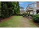 Lovely backyard featuring a well-kept lawn, mature trees, and a cozy patio area for outdoor enjoyment at 2174 Basque Se Dr, Smyrna, GA 30080