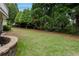 Expansive backyard featuring a well-maintained lawn and mature trees offering shade and privacy at 2174 Basque Se Dr, Smyrna, GA 30080