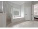 Bright bathroom featuring a soaking tub, a separate glass shower, and a decorative stained glass window at 2174 Basque Se Dr, Smyrna, GA 30080