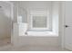 Bright bathroom featuring a soaking tub, a separate glass shower, and a decorative stained glass window at 2174 Basque Se Dr, Smyrna, GA 30080