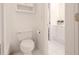 Bright and compact bathroom with a white toilet, white walls, and white tile floors at 2174 Basque Se Dr, Smyrna, GA 30080