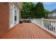 Wide wooden deck with white railing, surrounded by trees and offering space for outdoor seating at 2174 Basque Se Dr, Smyrna, GA 30080