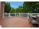 Cozy wooden deck with white railing and outdoor seating surrounded by greenery and tall trees at 2174 Basque Se Dr, Smyrna, GA 30080