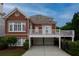 Rear exterior view showcasing a brick home with a spacious deck and attached two-car garage at 2174 Basque Se Dr, Smyrna, GA 30080