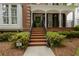 Inviting front entrance with brick steps, classic white columns, and lush landscaping, showcasing curb appeal at 2174 Basque Se Dr, Smyrna, GA 30080