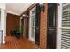 Charming front porch with brick floor and columns, complete with decorative lighting and black shutters at 2174 Basque Se Dr, Smyrna, GA 30080