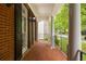 Covered front porch with brick flooring, white columns, and black railing, offering a relaxing outdoor space at 2174 Basque Se Dr, Smyrna, GA 30080
