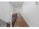 Hallway boasting hardwood floors, white trim, and iron railings leading to bedrooms and living spaces at 2174 Basque Se Dr, Smyrna, GA 30080