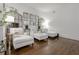 Bright living room featuring hardwood floors and white chaise lounges with accent mirrors on the walls at 2174 Basque Se Dr, Smyrna, GA 30080