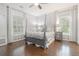 Primary bedroom featuring hardwood floors, four-poster bed, patterned wallpaper and abundant windows at 2174 Basque Se Dr, Smyrna, GA 30080
