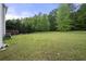 Expansive backyard featuring lush green grass, mature trees, and a deck, perfect for outdoor activities and relaxation at 4914 Brown Leaf Dr, Powder Springs, GA 30127
