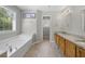 Bright main bathroom featuring a soaking tub and double vanity with granite countertop at 4914 Brown Leaf Dr, Powder Springs, GA 30127
