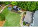 Aerial view showcases a charming backyard with a cozy fire pit and outdoor seating near mature trees at 5045 Huntwood Way, Roswell, GA 30075
