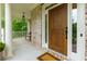 Inviting front entry featuring a wood door and adjacent covered porch at 5045 Huntwood Way, Roswell, GA 30075