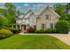 Beautiful brick home with a lush green lawn and mature landscaping at 5045 Huntwood Way, Roswell, GA 30075