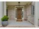 Charming covered front porch with brick accents and a classic wood front door at 5045 Huntwood Way, Roswell, GA 30075