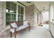 Inviting covered front porch with a comfortable bench at 5045 Huntwood Way, Roswell, GA 30075