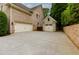 Spacious three-car garage with a light brick exterior and concrete driveway offering ample parking space at 5045 Huntwood Way, Roswell, GA 30075