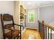 Hallway features hardwood floors, built-in shelving, window, and an ornate chair at 5045 Huntwood Way, Roswell, GA 30075