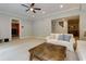 Open living room with plush carpeting, a ceiling fan and access to a basement bar area at 5045 Huntwood Way, Roswell, GA 30075