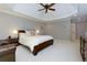 Main bedroom features a tray ceiling, large bed, and sitting area with a leather chair at 5045 Huntwood Way, Roswell, GA 30075