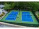 Aerial view of well-maintained tennis courts with benches and lighting for day and night play at 5045 Huntwood Way, Roswell, GA 30075