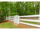 Landscaped yard with a white fence and lush trees at 5045 Huntwood Way, Roswell, GA 30075