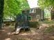 The backyard offers a trampoline and slide plus brickwork, perfect for Gathering fun and outdoor enjoyment at 555 Creekwood Xing, Roswell, GA 30076
