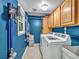 Bright laundry room with modern washer and dryer, plus ample storage cabinets and shelving for convenience at 555 Creekwood Xing, Roswell, GA 30076