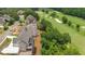 Aerial view of a luxury home adjacent to a golf course, showcasing premier community living and scenic views at 5753 Brendlynn Dr, Suwanee, GA 30024