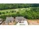 Aerial shot featuring a stunning new home in a gated community next to a lush green golf course at 5753 Brendlynn Dr, Suwanee, GA 30024