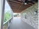 Covered back deck with a ceiling fan and brick siding, overlooking a wooded area at 5753 Brendlynn Dr, Suwanee, GA 30024