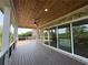 Covered back deck with wood ceiling, ceiling fan, brick accents, and outdoor living space at 5753 Brendlynn Dr, Suwanee, GA 30024