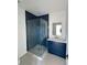 Modern bathroom with glass shower and blue vanity at 5753 Brendlynn Dr, Suwanee, GA 30024