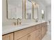 Elegant bathroom featuring double vanity, white countertops, gold fixtures, and warm wood cabinetry at 5753 Brendlynn Dr, Suwanee, GA 30024