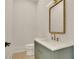 Stylish powder room with a decorative mirror and a green vanity with marble countertop at 5753 Brendlynn Dr, Suwanee, GA 30024