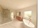 Luxurious bathroom with marble floors, dual sinks, soaking tub, and glass-enclosed shower at 5753 Brendlynn Dr, Suwanee, GA 30024